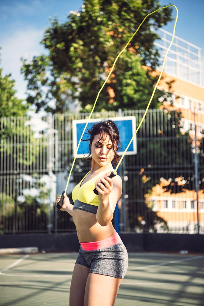 Fitness woman doing skipping workout with jump rope