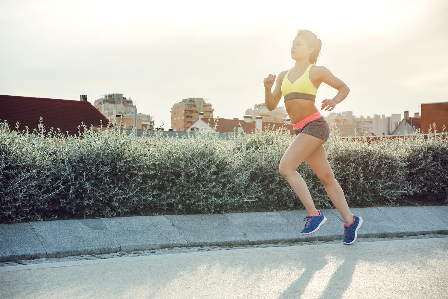 Running woman is jogging in sunny bright light on sunrise