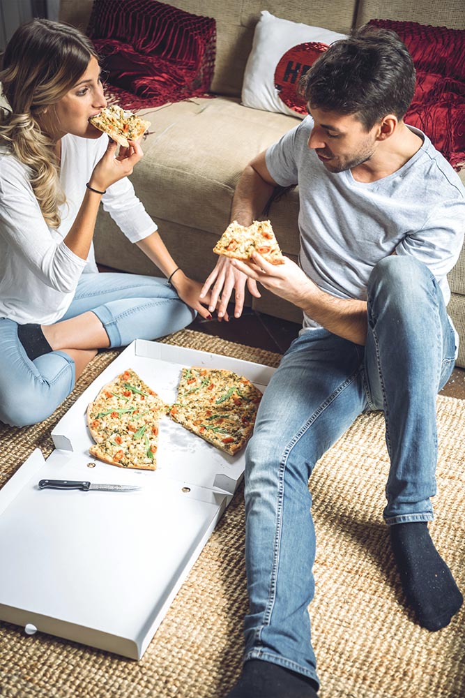 Two young couple enjoying pizza