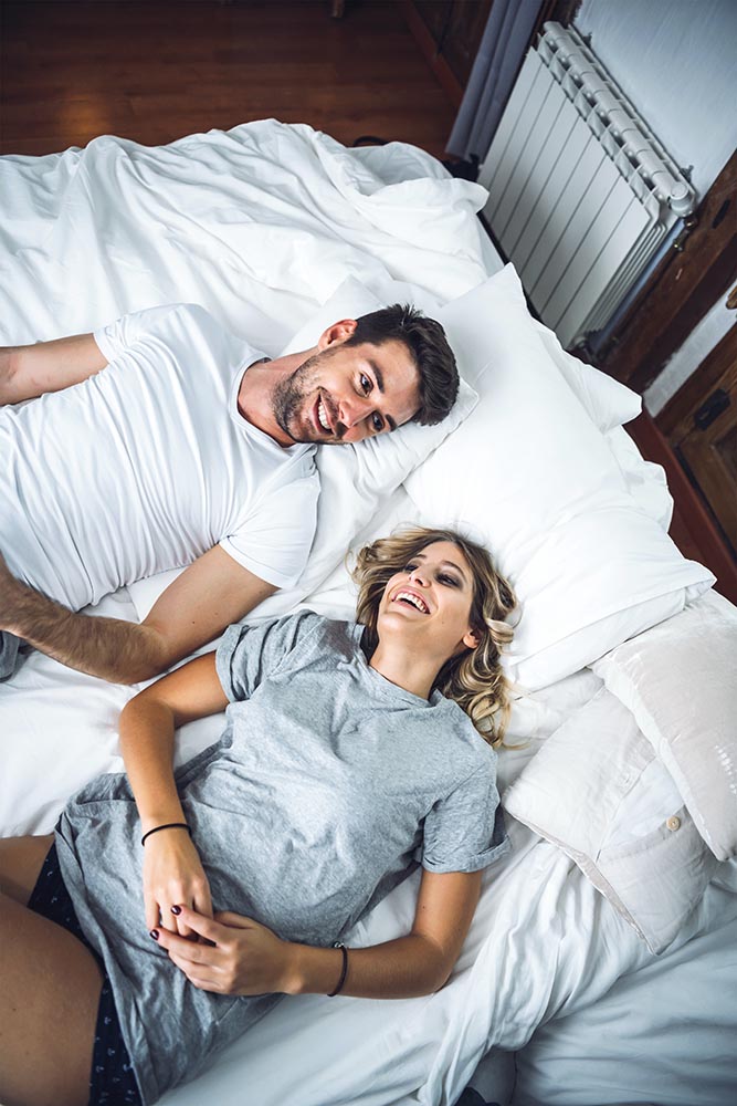 Romantic couple laughing in bed