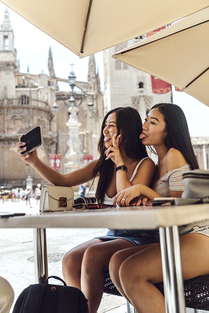 Chinese women sitting at table making selfie