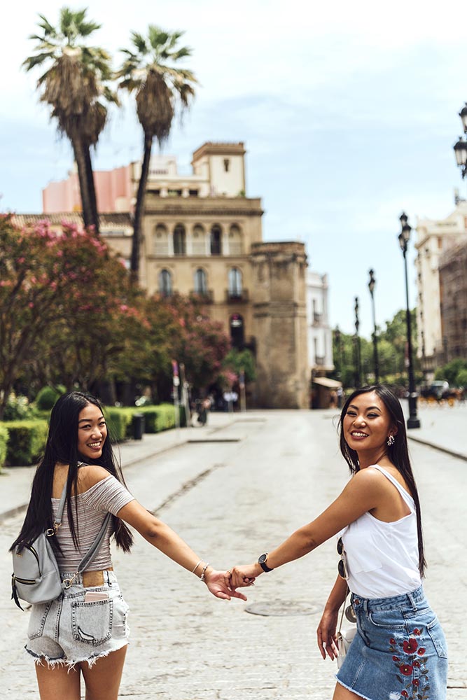 Two Chinese girls standing holding hands