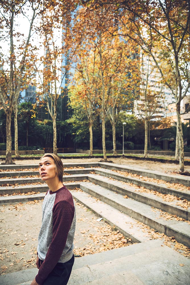 Young dreaming man in autumnal park