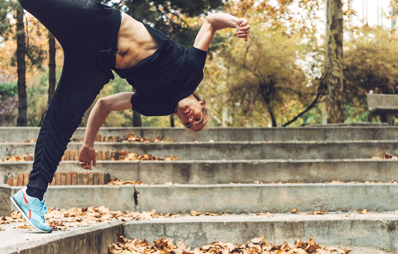 Muscular man performing jump in park