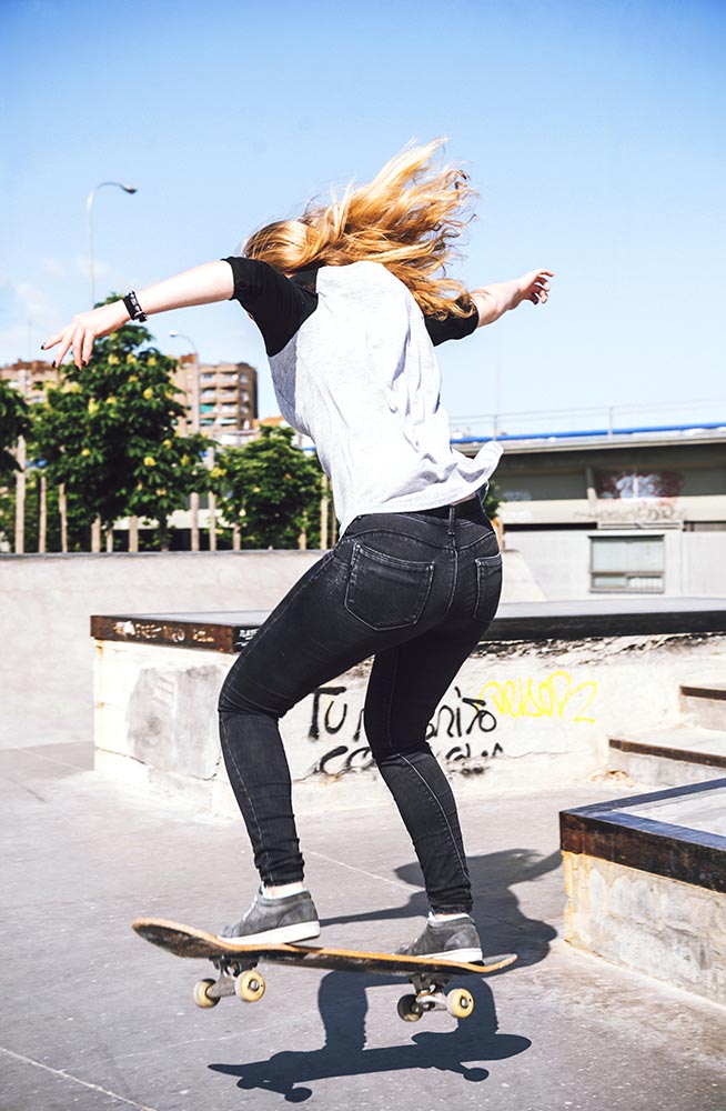 Skateboarding woman practicing at skatepark