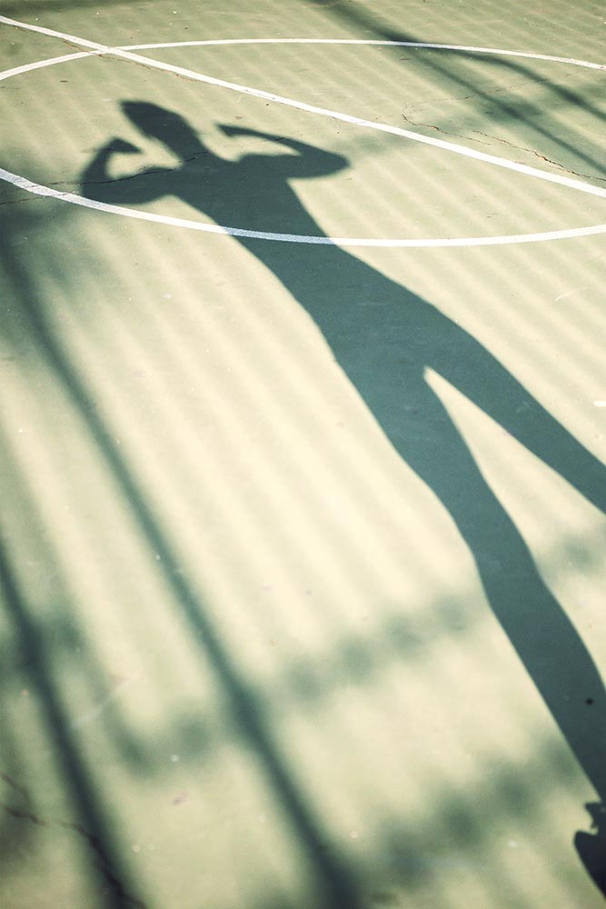 Shadow of running woman on a basketball court