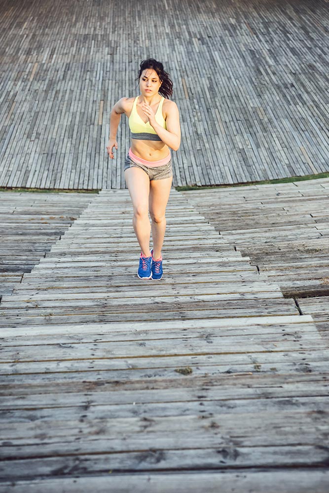 Runner athlete running at wooden stairs. woman fitness jogging w