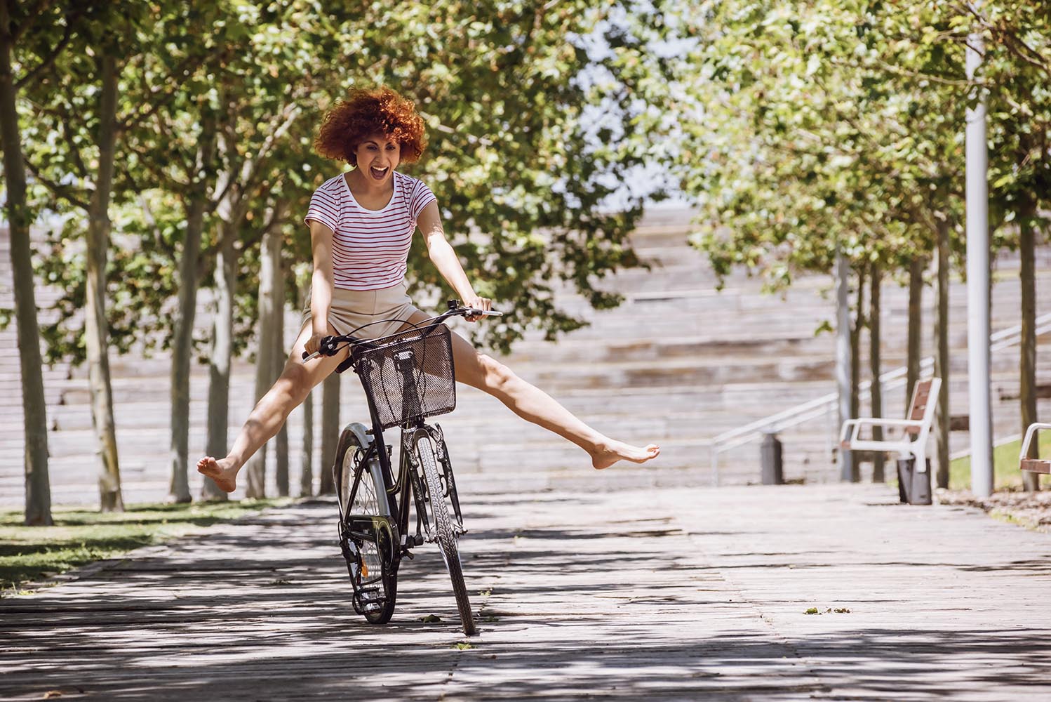 Cheerful girl riding a bike down the street