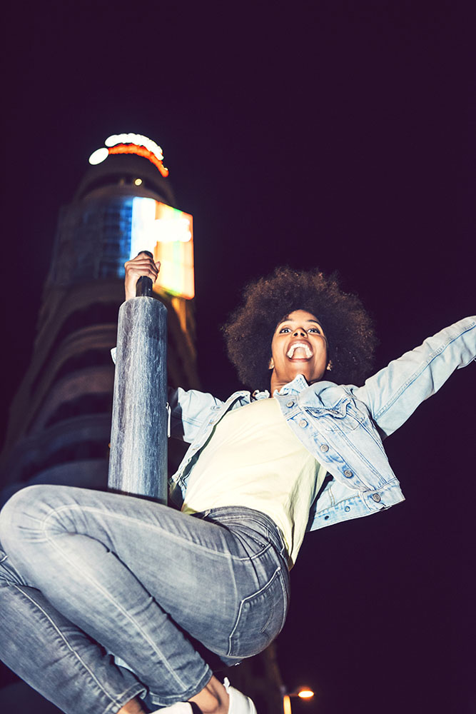 Beautiful black woman perched on a pole partying