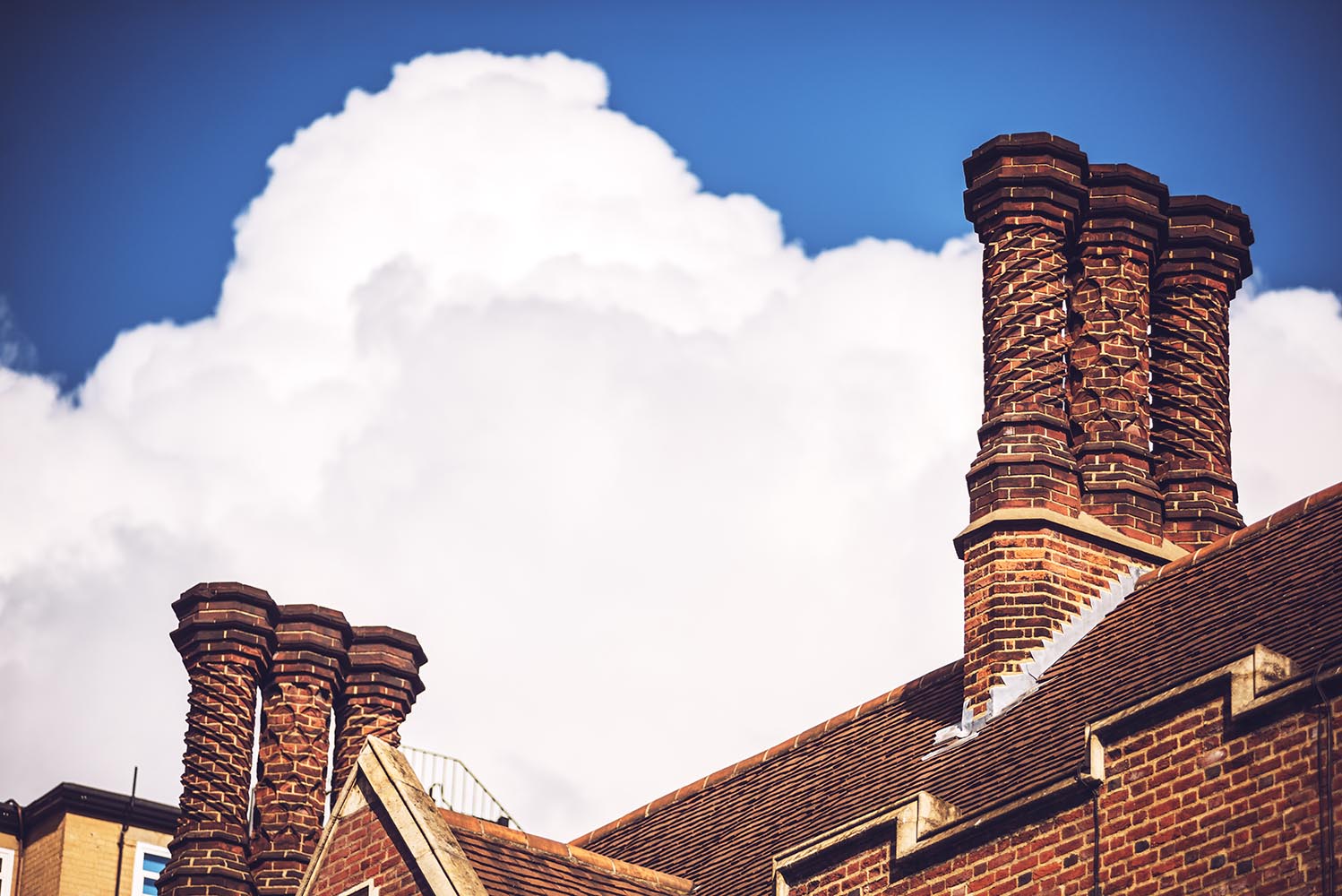Brick chimney over clouds.