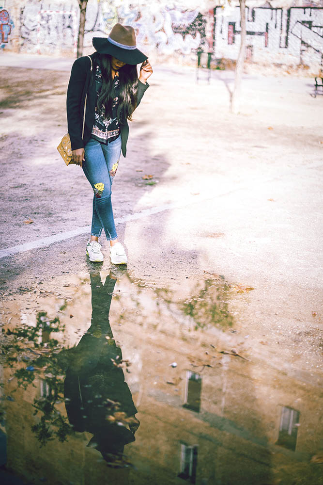 Black Female standing on playground near puddle