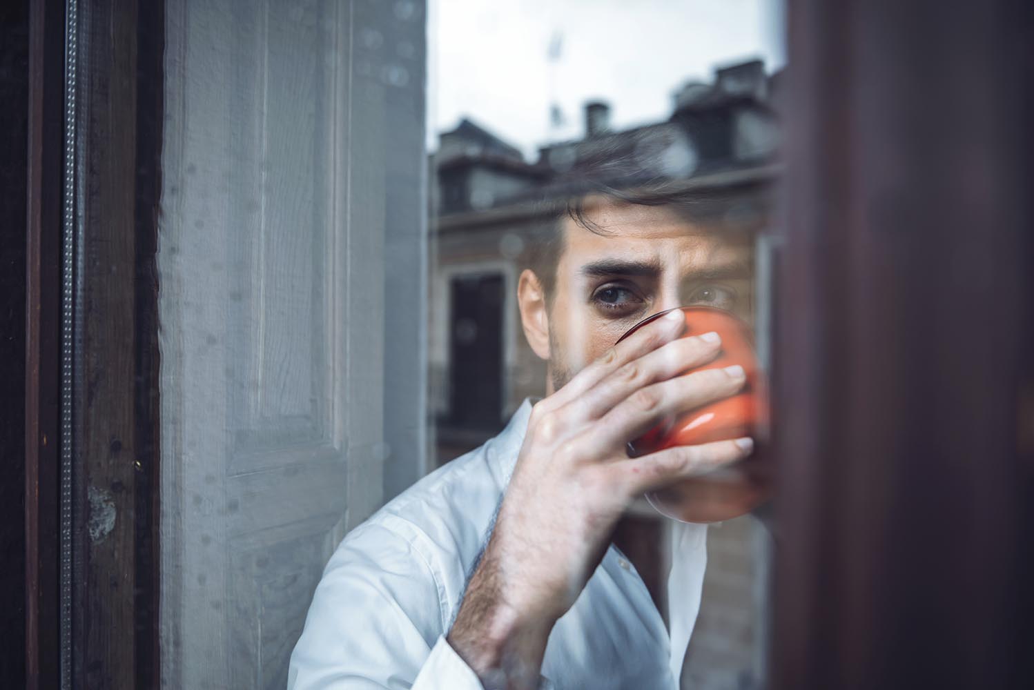 Handsome male drinking tea in rainy day