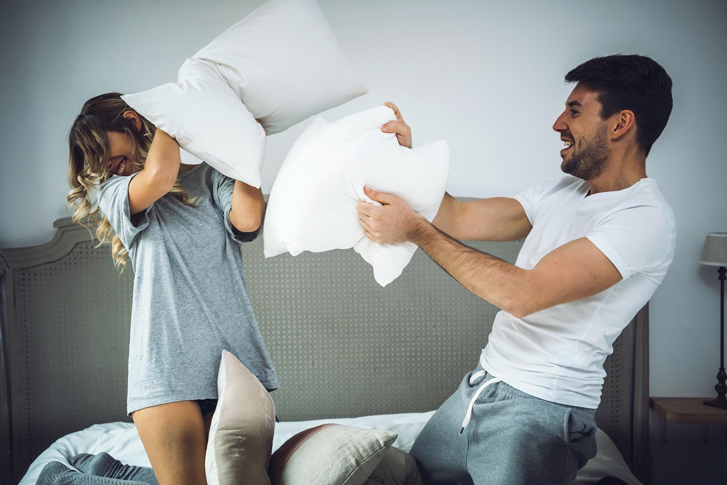 Happy couple fighting with pillows