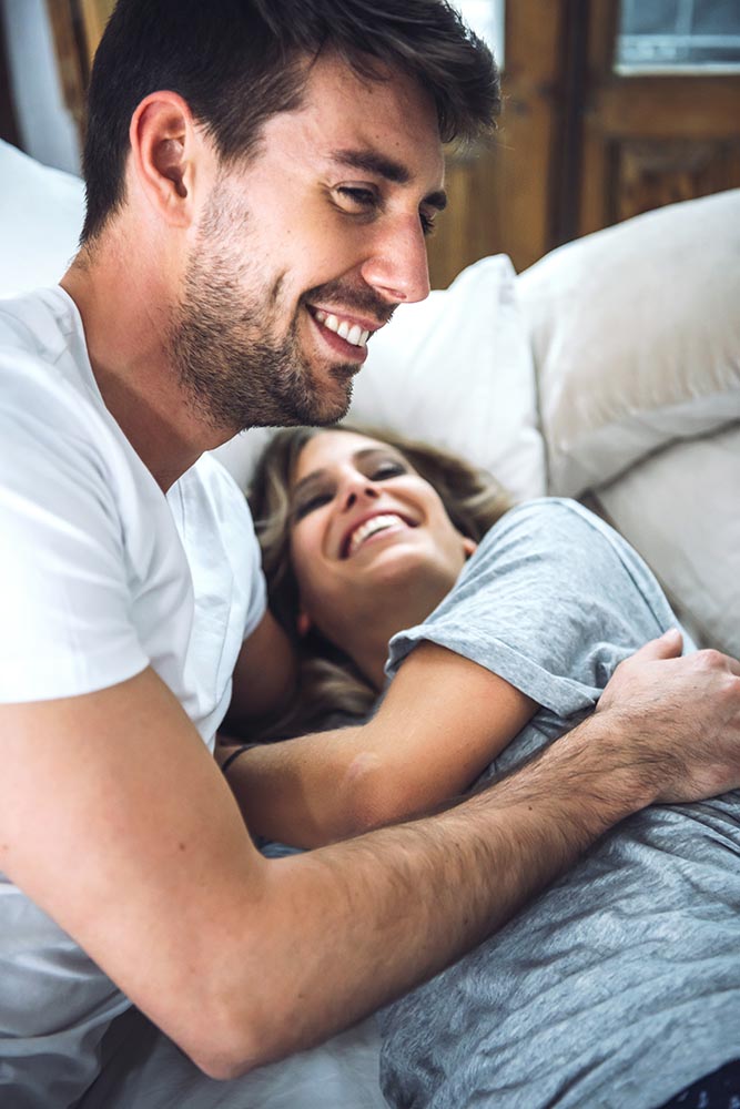 Adorable couple laughing in bed