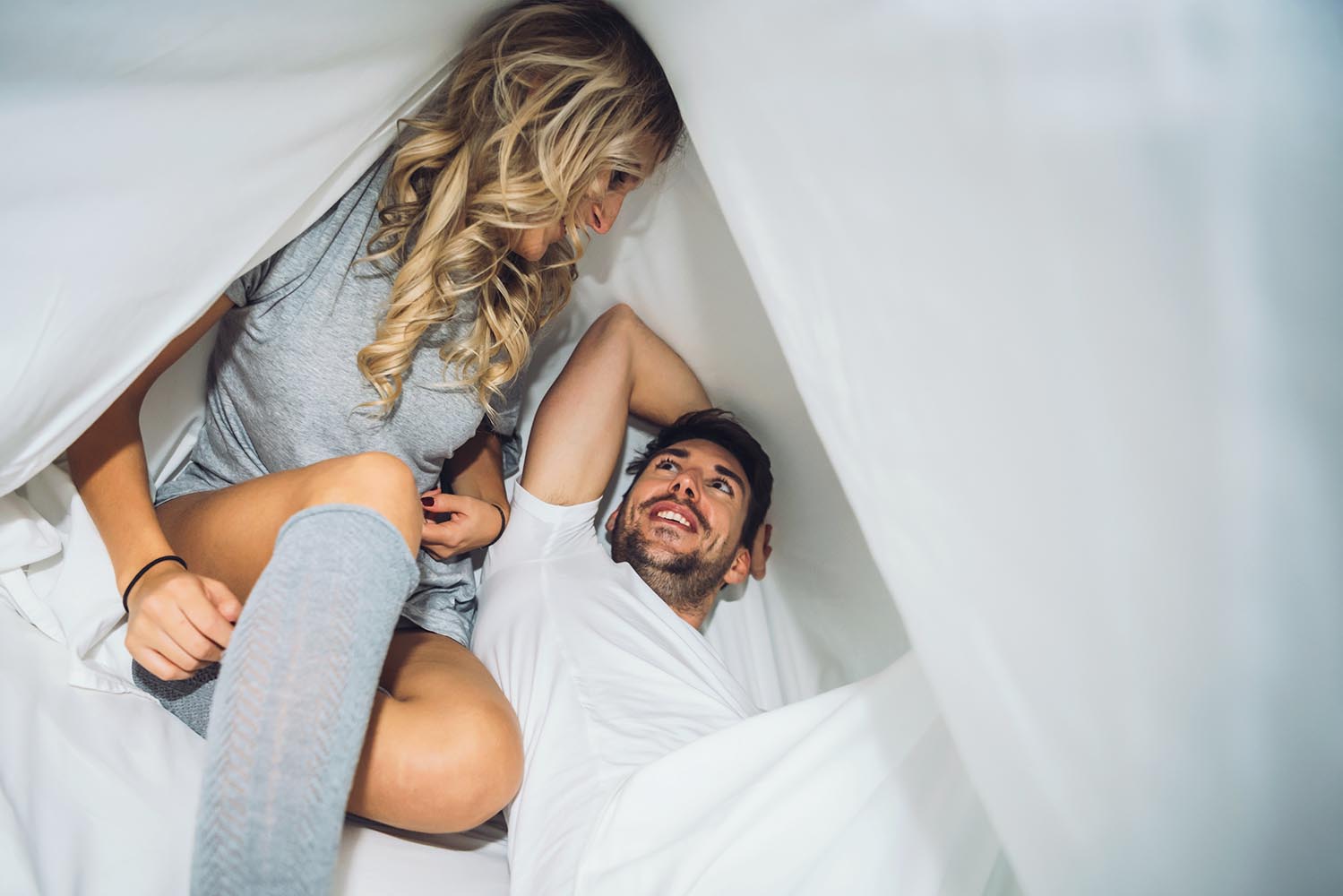 Couple playing under sheets