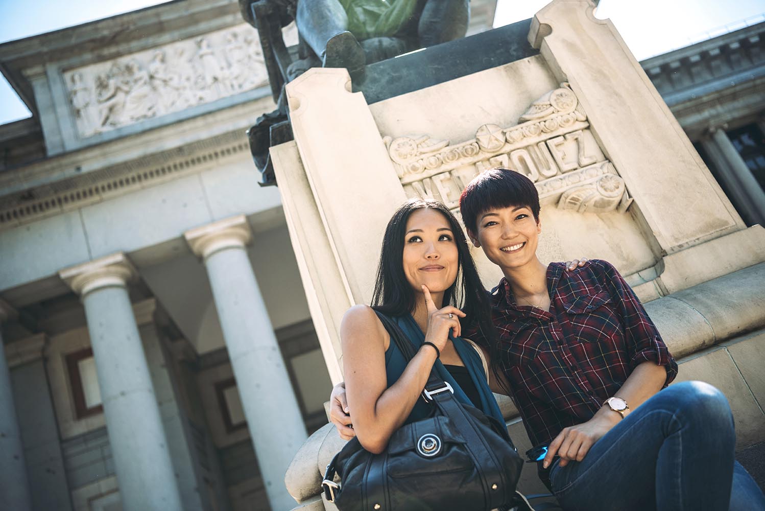 Asian female tourists sitting at monument