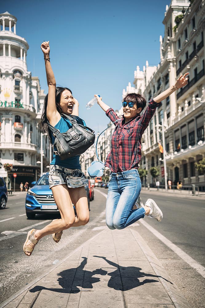 Happy girls jumping on street