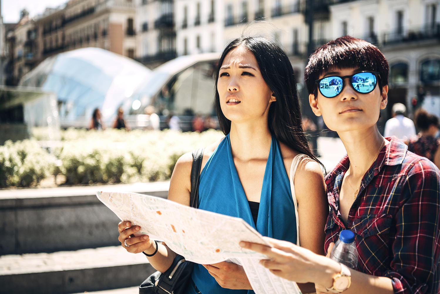 Asian tourist women with map on street