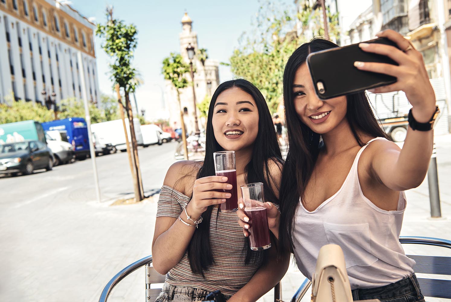 Chinese girls making selfie holding glasses