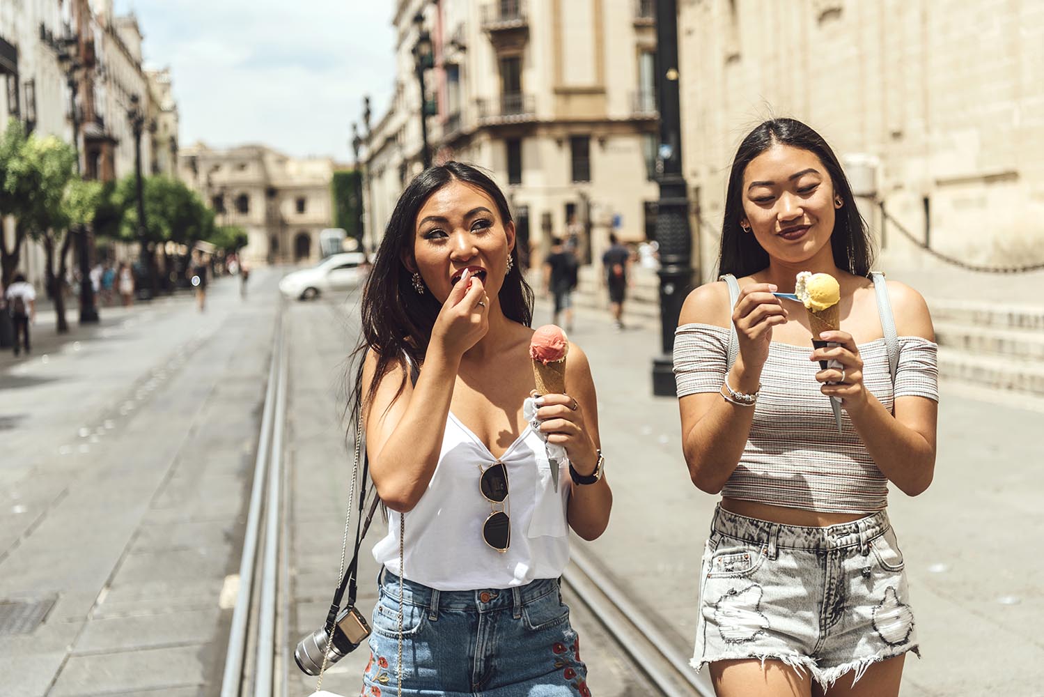 Two Chinese girls eating ice cream walking