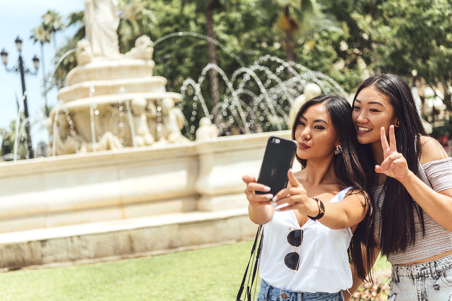 Two Chinese girl taking selfie at fountain