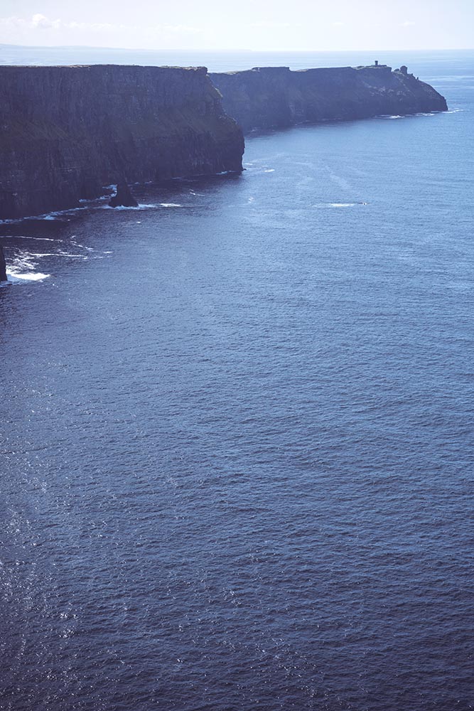 Massive cliffs of Moher on Atlantic ocean on sunny day, Ireland