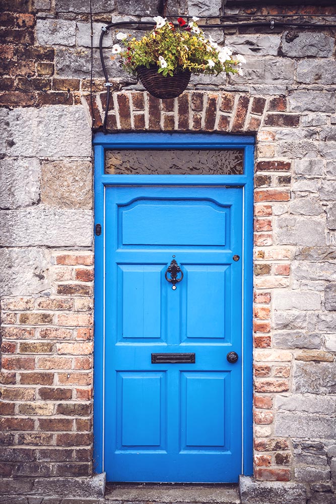 Bright blue door in brick wall of English house.