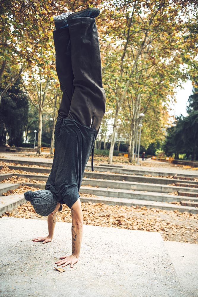 Sportive man doing handstand in park