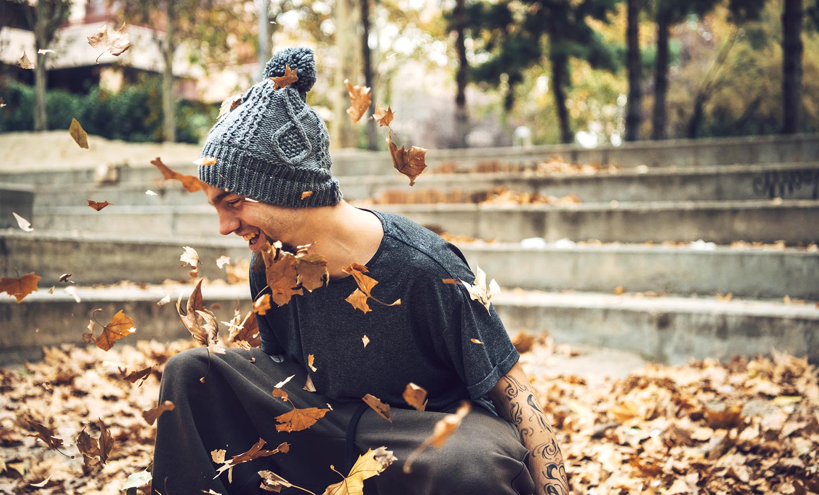 Laughing sportive man in leaves