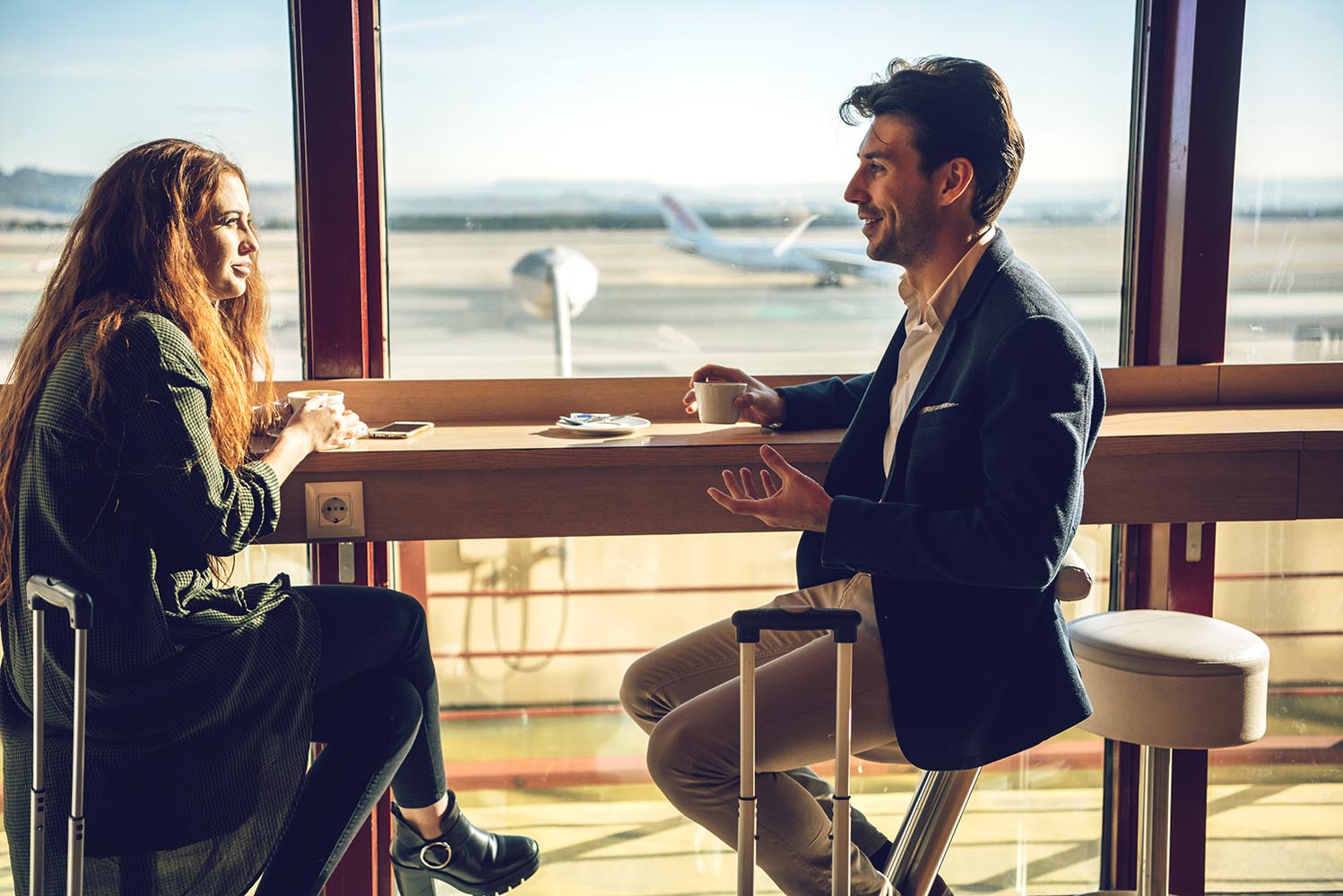 Happy couple sitting in airport cafe