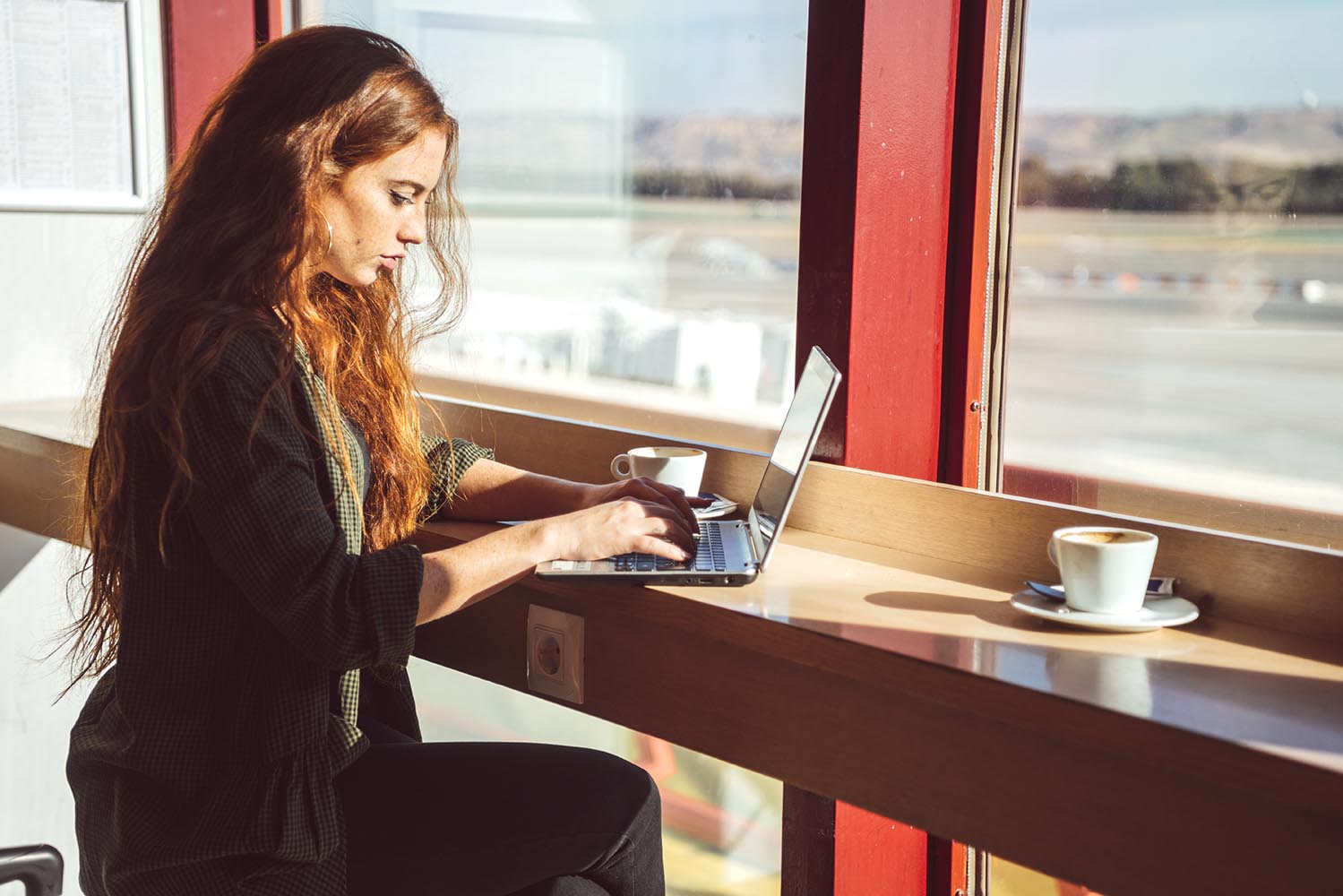 Woman with laptop in airport cafe