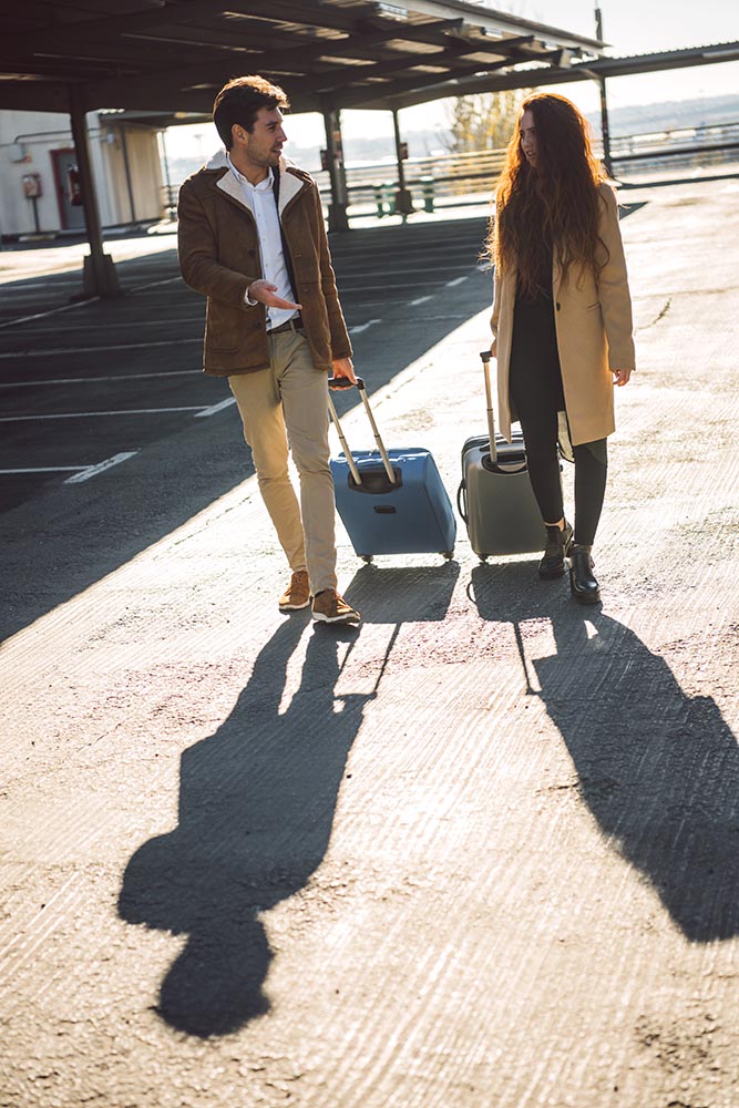 Stylish couple with baggage walking