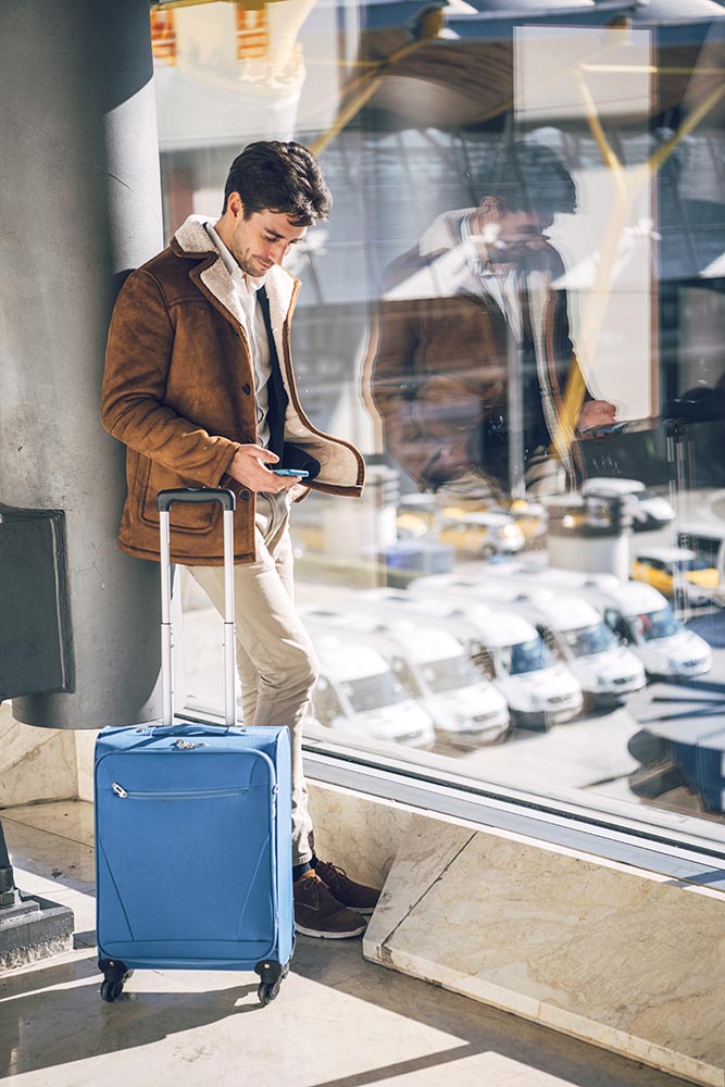 Man with smartphone and suitcase