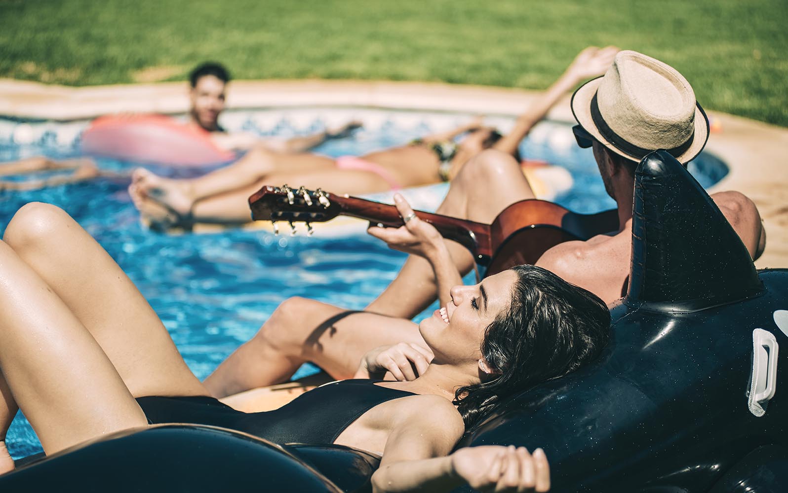 Men and women relaxing in poolside