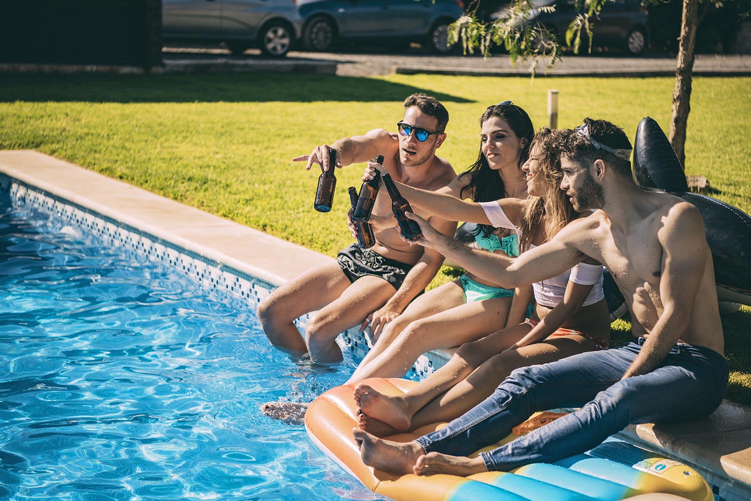 Friends drinking beer on poolside