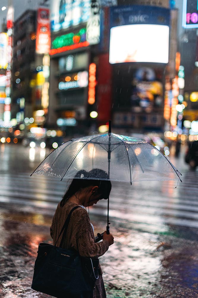 Shibuya, people crossing the street under the rain at night. Tok